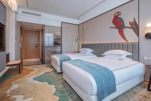 a bedroom with two beds and a painting of a bird at Wellay Hotel Ningbo Jiangbei Olympic Sports Center in Ningbo