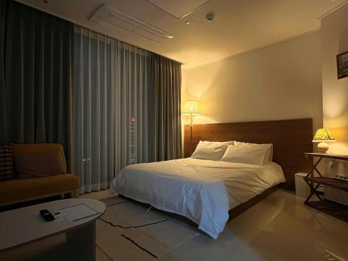 a hotel room with a bed and a chair at Yeonsan The Stay in Busan