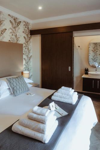 a hotel room with two beds with towels on them at The Feather Hill Boutique Hotel in Potchefstroom
