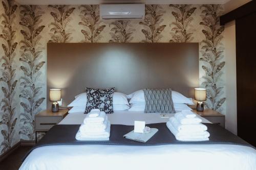 a bedroom with a bed with towels on it at The Feather Hill Boutique Hotel in Potchefstroom