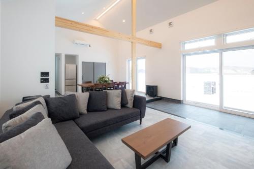 a living room with a couch and a table at HIGASHIKAWA Villa 森音 in Higashikawa