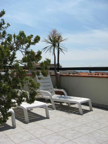 two white chairs sitting on top of a roof at Hotel Rosati in Rimini
