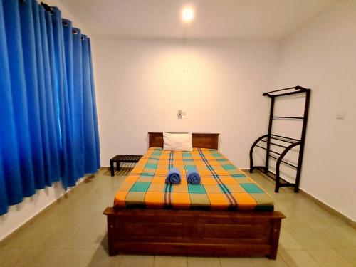 a bedroom with a bed in a room with blue curtains at The Lovina Place in Mount Lavinia