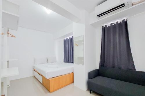 a small room with a bed and a chair at Luxury Studio at 19th Floor Apartment Urbantown Serpong By Travelio in Tangerang