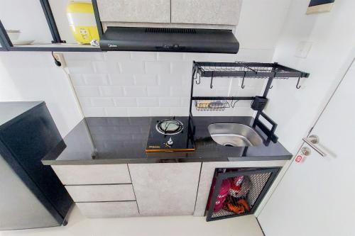 an overhead view of a small kitchen with a sink at Luxury Studio at 19th Floor Apartment Urbantown Serpong By Travelio in Tangerang