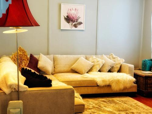 a living room with a couch with pillows at Magnolia Cottage in Healesville