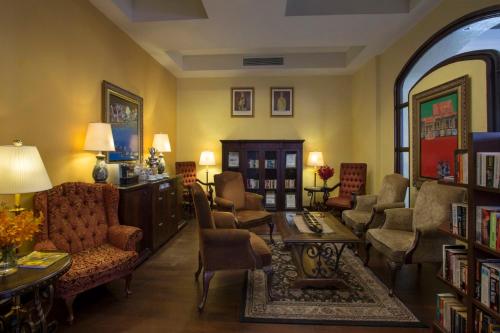 a living room filled with lots of chairs and a table at Casa del Rio Melaka in Melaka