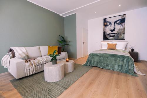a living room with a couch and a bed at Waterfront Riverside Premium Suites by ORY Living in Hamburg