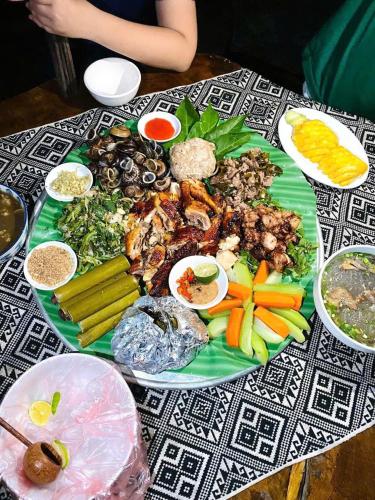 a green plate of food on a table at Mai Chau Home Holiday in Mai Chau