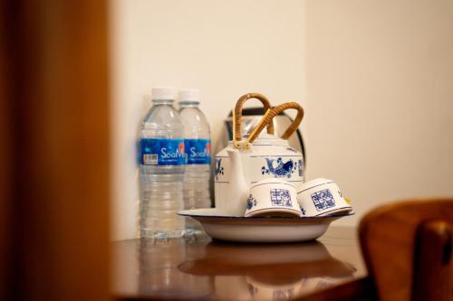 a table with a tea pot and bottles of water at Tian Jing Hotel in Kuala Lumpur