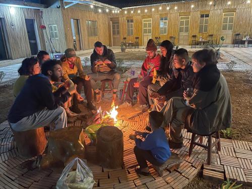 a group of people sitting around a fire at Mai Chau Home Holiday in Mai Chau