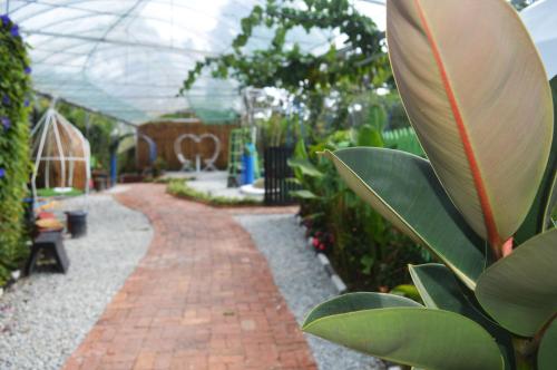 a garden with a brick pathway in a greenhouse at Glamz Hills in Cameron Highlands