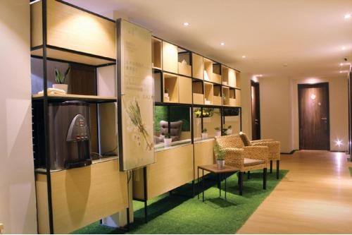 a lobby with a waiting room with a couch and chairs at Sojourn Guest House in Kuala Lumpur