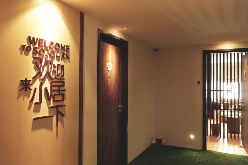 a hallway with a door and a clock on the wall at Sojourn Spa Hotel in Kuala Lumpur