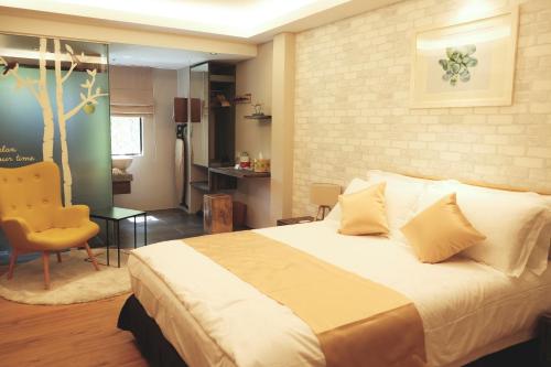 a bedroom with a large bed and a chair at Sojourn Spa Hotel in Kuala Lumpur