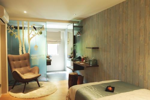 um quarto com uma cadeira, uma cama e uma janela em Sojourn Guest House em Kuala Lumpur