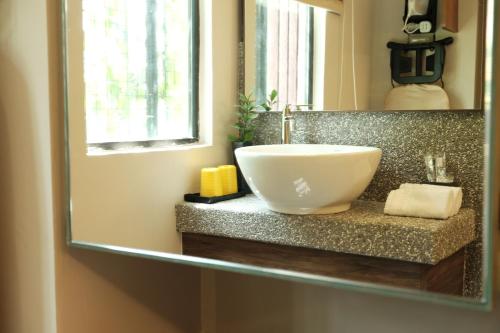a bathroom with a bowl sink in a mirror at Sojourn Spa Hotel in Kuala Lumpur