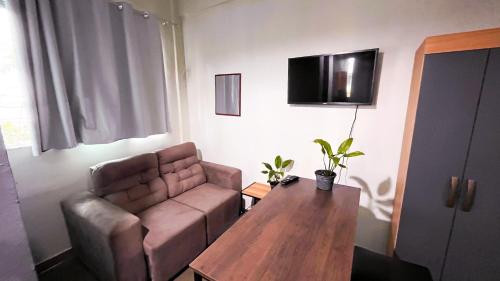 a living room with a couch and a table at Hotel e Restaurante Casa Paraense Original, px ao aeroporto in Manaus
