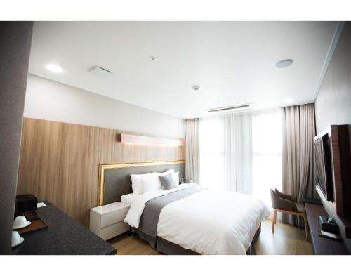 a hotel room with a bed and a television at Hotel L'art Gimpo in Gimpo