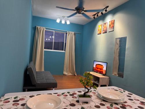 a blue living room with a table and a television at charming 1br retreat in bayan lepas 1car park Malaysian guest only Netflix in Bayan Lepas