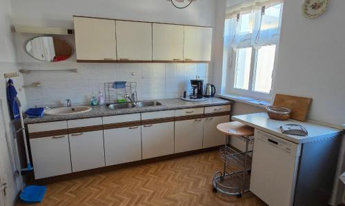 a kitchen with white cabinets and a sink and a window at Haus Marienblick in Beeskow