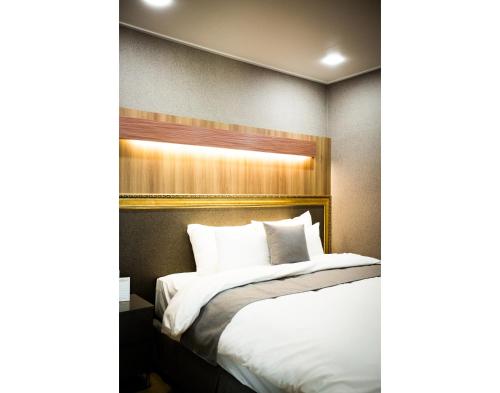 a hotel room with a bed with white pillows at Hotel L'art Gimpo in Gimpo