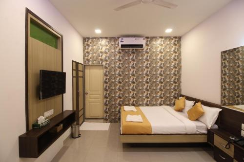 - une chambre avec un lit et une télévision dans l'établissement Golden Residency, à Mumbai