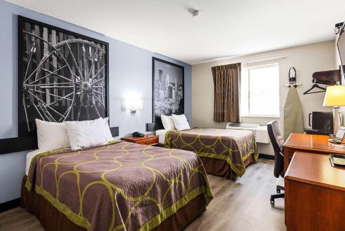 a hotel room with two beds and a desk at Super 8 by Wyndham Pittsburgh/Monroeville in Monroeville