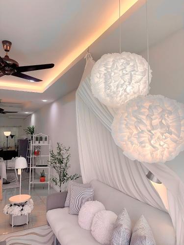 a living room with a white couch and two lights at Blubelle Apt Near Lake Garden Zoo With Wifi Netflix in Taiping