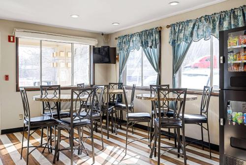 a dining room with tables and chairs and windows at Super 8 by Wyndham Pittsburgh/Monroeville in Monroeville
