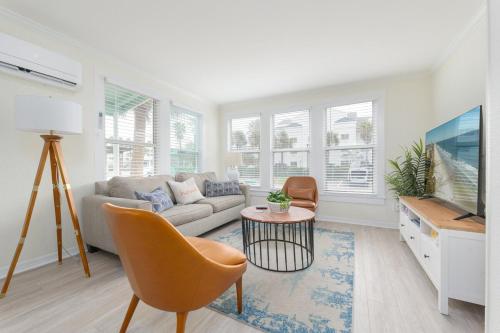 a living room with a couch and a tv at Be a Nomad - Ocean Breeze - Steps from Beach in Jacksonville Beach