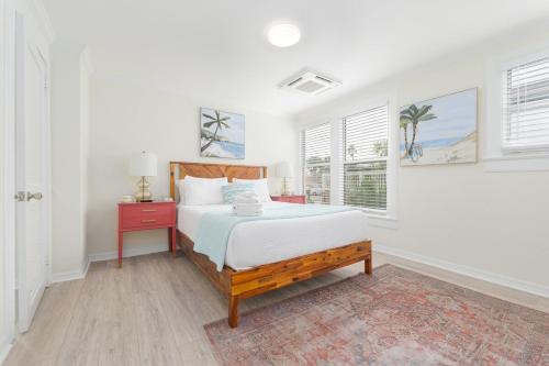 a white bedroom with a bed and a window at Be a Nomad - Ocean Breeze - Steps from Beach in Jacksonville Beach