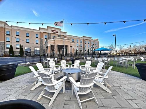 a group of white chairs and tables in front of a building at Hampton Inn and Suites Robbinsville in Robbinsville