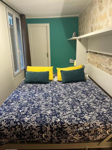 Cette petite chambre comprend un lit avec des oreillers jaunes et bleus. dans l'établissement Paris Arts et Métiers, à Paris