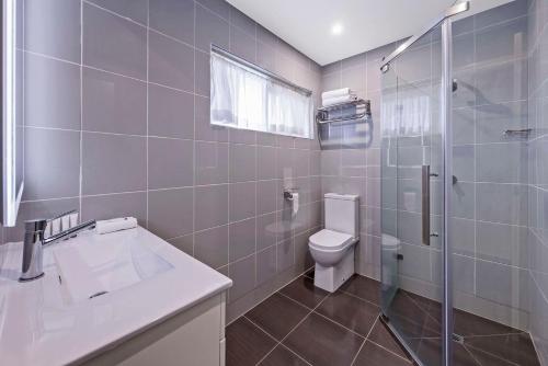 a bathroom with a toilet and a shower and a sink at Quality Hotel Melbourne Airport in Melbourne