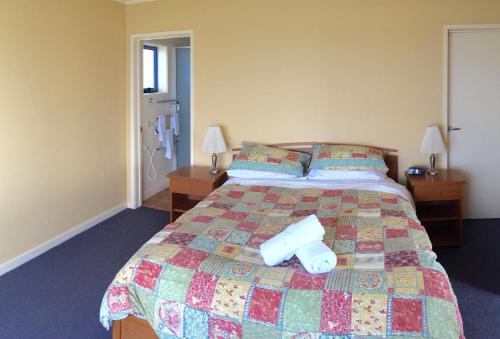 a bedroom with a bed with a roll on it at Horizons Beachfront Apartment in Port Fairy