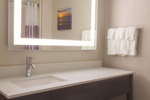 a bathroom with a sink and a mirror and towels at La Quinta by Wyndham Columbus North in Columbus