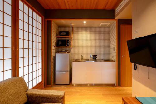 a small kitchen with a refrigerator and a sink at GOZAN HOTEL & SERVICED APARTMENT Higashiyama Sanjo in Kyoto