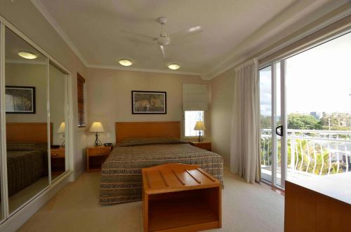 a hotel room with a bed and a balcony at Myconos Resort in Maroochydore
