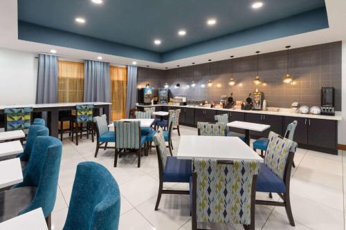 a restaurant with tables and chairs and a bar at La Quinta by Wyndham Austin NW/Lakeline Mall in Cedar Park