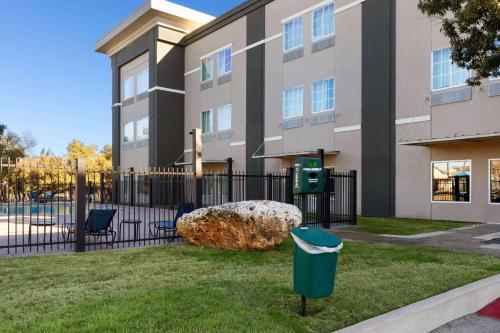 a building with a trash can in front of a fence at La Quinta by Wyndham Austin NW/Lakeline Mall in Cedar Park