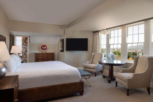 a hotel room with a bed and a table and chairs at Hotel Roanoke & Conference Center, Curio Collection by Hilton in Roanoke