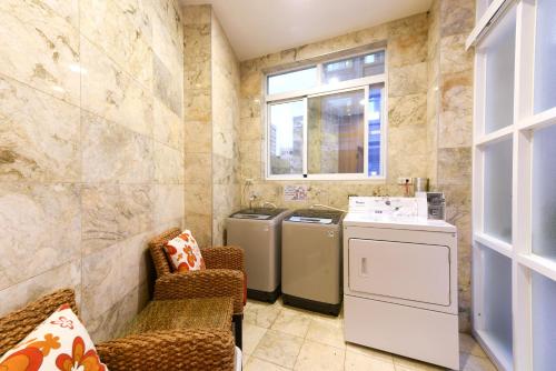 a laundry room with two washers and a window at Blue Coast Hotel in Kaohsiung