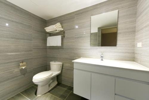 a bathroom with a toilet and a sink and a mirror at Blue Coast Hotel in Kaohsiung