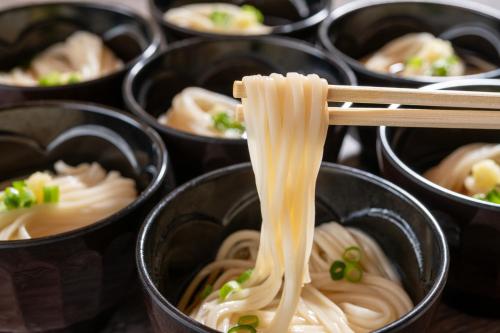 a group of bowls filled with noodles and peas at KAMENOI HOTEL Tazawako in Senboku
