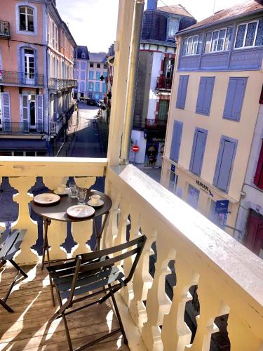 un balcon avec une table et des chaises sur un balcon dans l'établissement Appartement Tout Confort Coeur de Ville Grand Balcon Le Néouvielle, à Bagnères-de-Bigorre