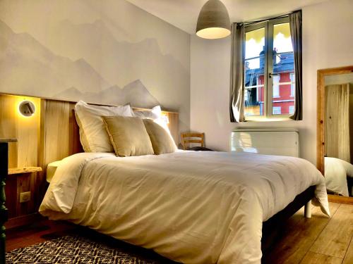 - une chambre avec un grand lit orné d'une fresque murale représentant la montagne dans l'établissement Appartement Tout Confort Coeur de Ville Grand Balcon Le Néouvielle, à Bagnères-de-Bigorre