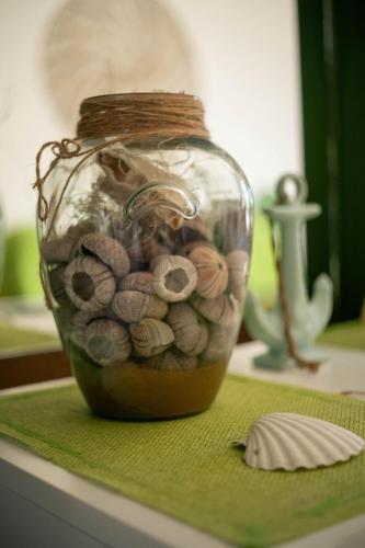 a glass jar filled with seashells on a table at Gariga Holidays Apartments in Nardò