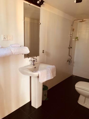 a bathroom with a sink and a toilet at Mel's Inn in Negombo