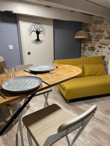 un salon avec une table et un canapé jaune dans l'établissement Séjour à la Marronnie, à Saint-Germain-les-Vergnes